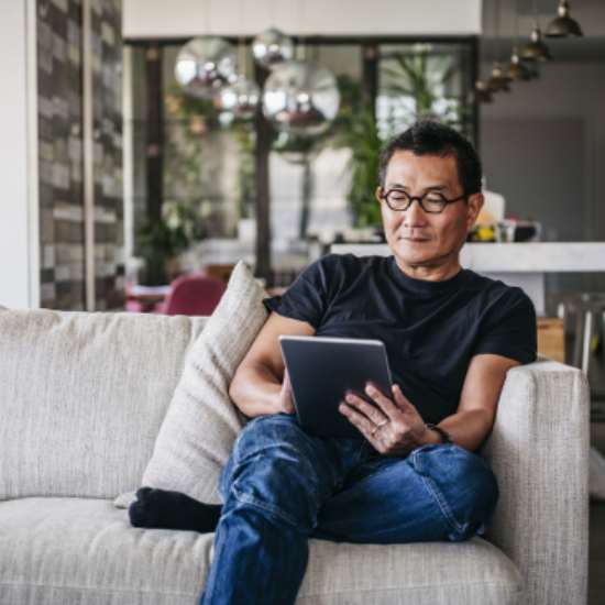 Man met tablet op bank