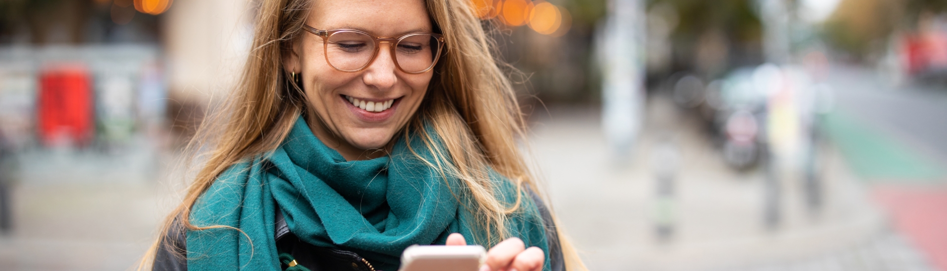 Vrouw op straat met mobiel in hand